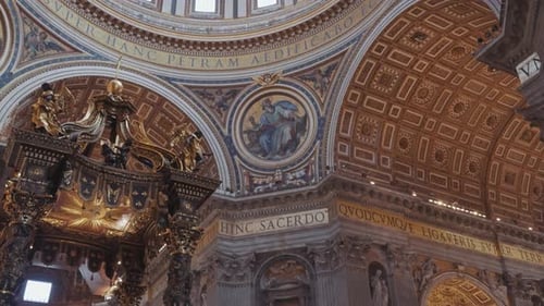 Panning up interior view of St. Peter’s Basilica focuses on the towering dome and decorated