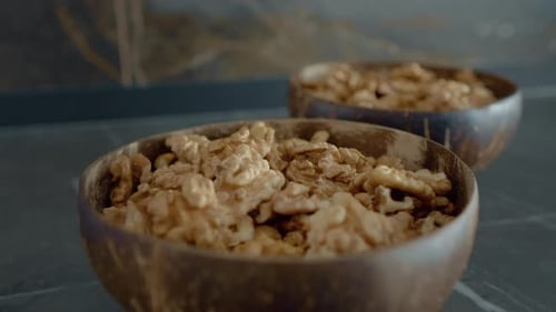 Walnut halves in coconut bowls on kitchen counter