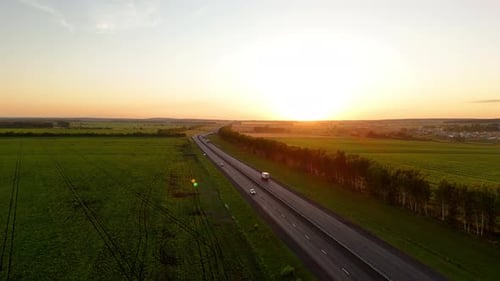 Heavy Truck Driving on an Asphalt Road Along Green Fields Top View