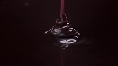 pouring in smooth, rich flow, detailed spiral dispersing into darkness, slow motion