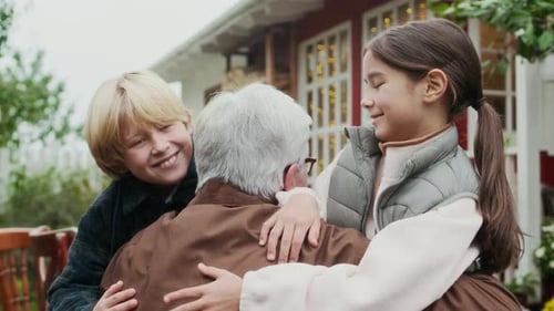 Grandchildren Giving Heartwarming Hug to Grandfather in Cozy Garden