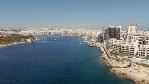 An aerial view of the resort town of Sliema in Malta on a sunny morning. Flying towards the harbour