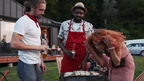Stylish Young Friends Enjoying Beer and Aroma of Frying Sausages on Grill Joking and Laughing Men