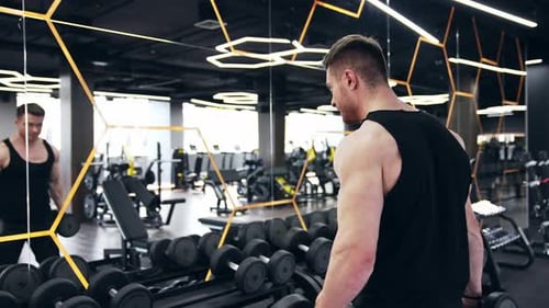 Junger professioneller Sportler, der an einer Trainingsübung für die Bizeps-Armmuskulatur arbeitet