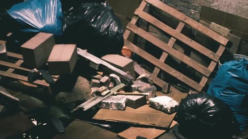 Discarded Waste and Debris in a Cluttered Alleyway During Daylight Hours