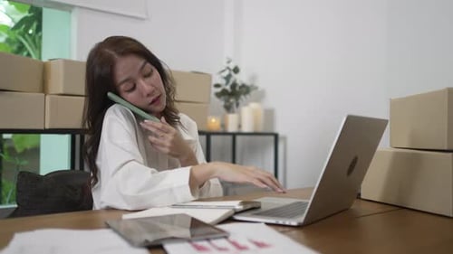 Woman Working at Laptop, Talking on Phone