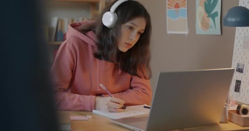 Teen Studies with Laptop and Notebook at Home