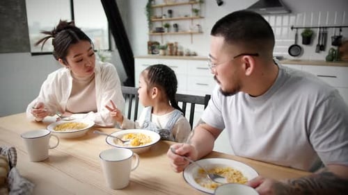 Family Having Breakfast Together at Home in Kitchen