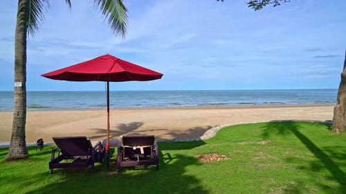 red umbrella and beach chair with sea beach background and blue sky and sunlight