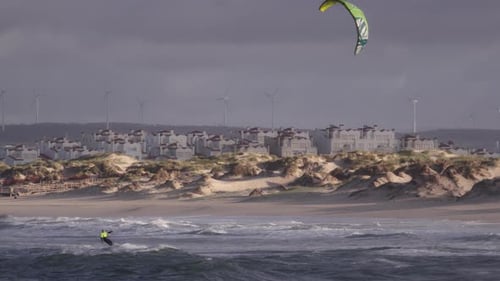 Kiteboarding on waves of Atlantic ocean in slow motion, stable copyspace cinematic view