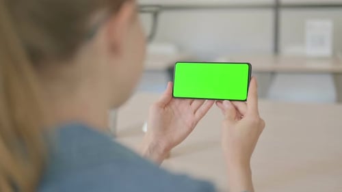 Young Woman Holding Smartphone with Green Screen