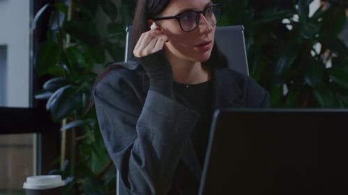 A Young Girl is Working on a Laptop in a Office with Plants Portrait of Serious Business Woman