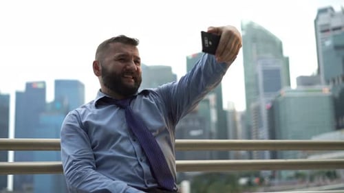 Happy Businessman Taking Photo with Cellphone in the City 40s