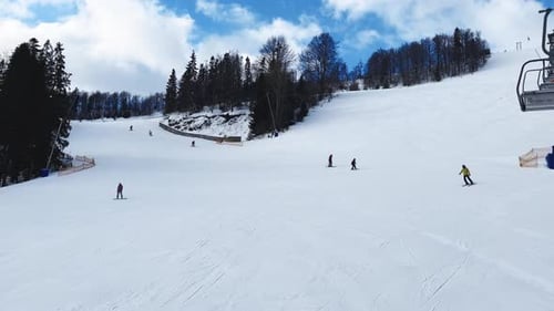 Skiers Skiing Downhill in Winter Resort Mountains