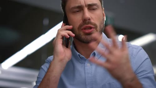 Focused Manager Speaking Cell Phone Discussing Serious Business Information in Company Office