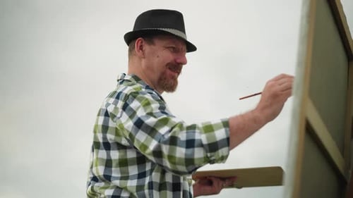 Artist Painting on Canvas Outdoors in Daylight