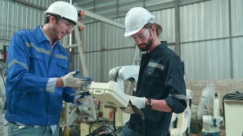 The two engineers check the operation of welding robots
