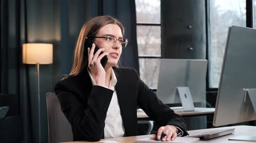 Focused Businesswoman Working on Laptop Computer in Office Interior