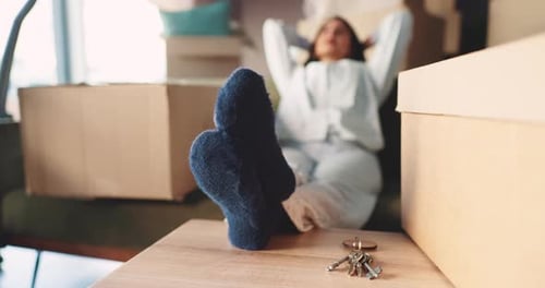 Relax, real estate and woman in new home with boxes, keys and moving to dream house