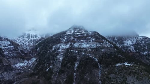 Snow-covered mountain peak in Aragón, Spain, near Canfranc-Estación, shrouded in mist