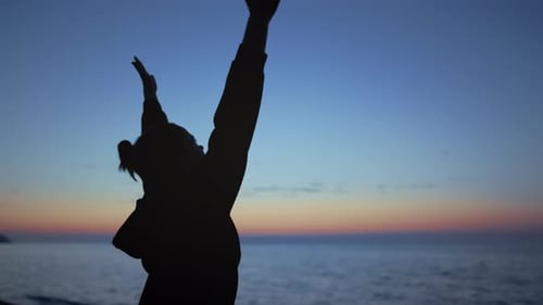 Silhouette Yoga-Frau, die nach einem schönen Abendhimmel aus nächster Nähe greift. Junge Sportlerin erzieht H...