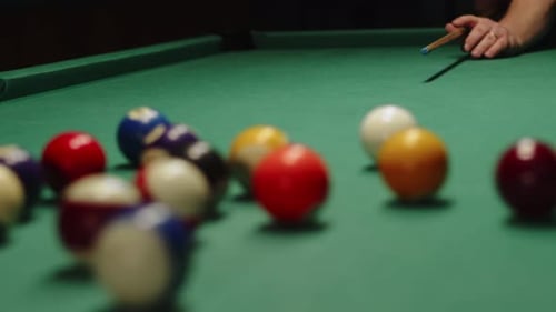 Closeup Billiard Balls on Table Man Hits Cue and Breaks Pyramid of Balls Front View Mans Hand Hits