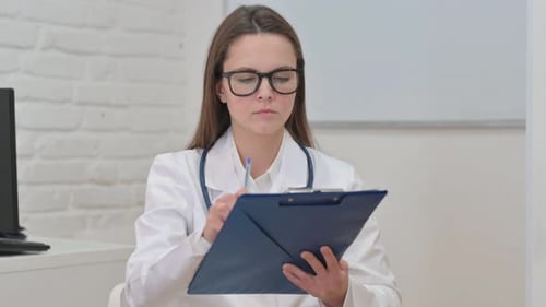 Portrait of Young Female Doctor Working on Medical Report