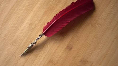 Feather Pen on Wood Background Rotates