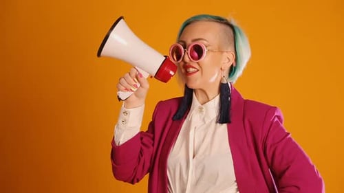 Stylish Woman with Bullhorn on Orange Background