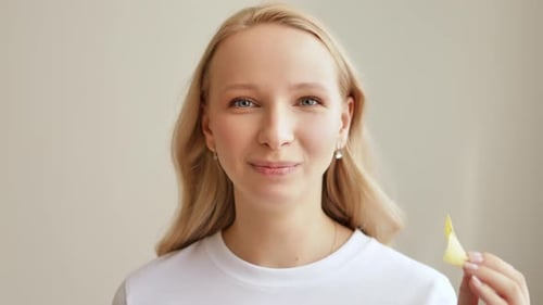 Smiling woman eats potato chip close up indoors