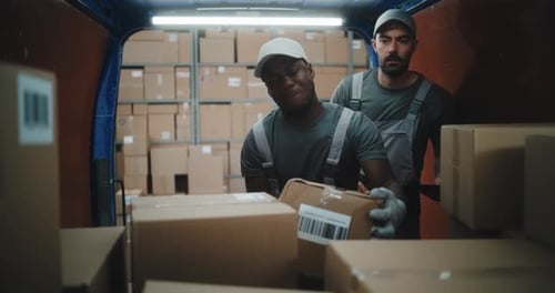 Multiethnic Workers Scanning Cardboard Boxes with Online Orders in Delivery Truck