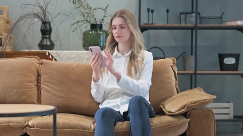 Woman Using Smartphone While Sitting on Couch