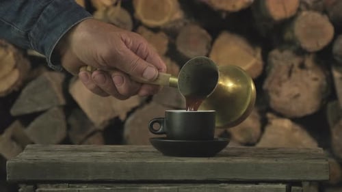 Steaming Coffee Being Poured into Black Cup