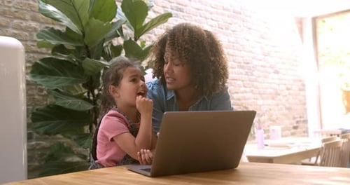 Woman and Child Using Laptop at Home