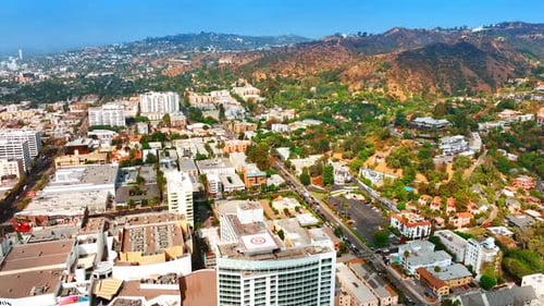 Hills of Los Angeles with multiple buildings at the foot.