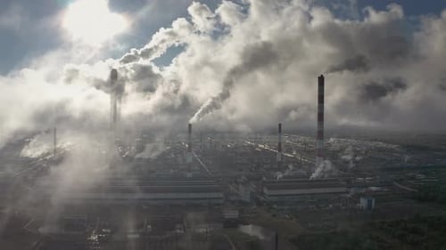 Power plant smokes. Aerial view of the power plant with smoking pipes and clouds passing by