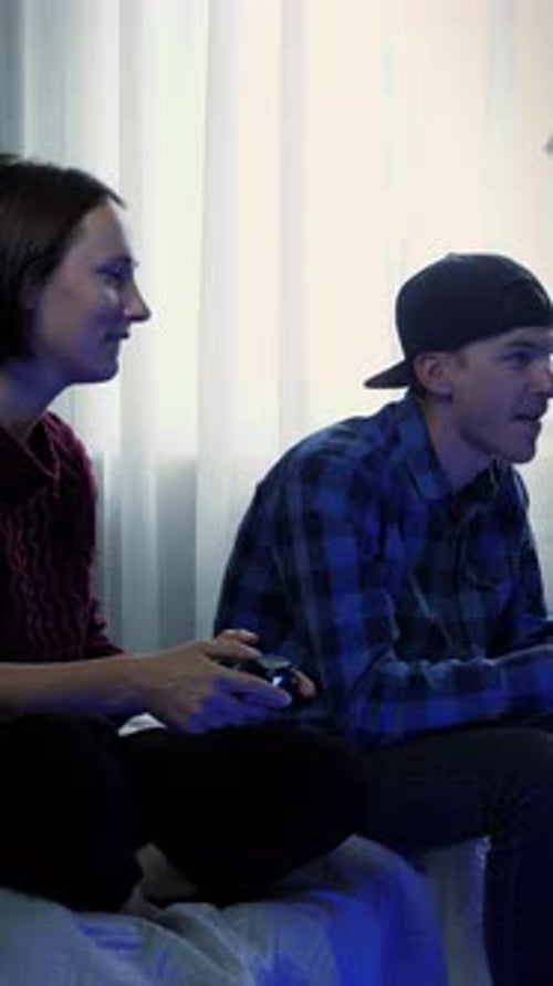 Woman and Man Playing Video Games on Bed