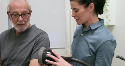 Senior Man Receives Therapy From Adult Woman