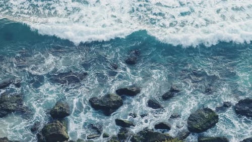 Wellen krachen über Felsen in wunderschönem türkisfarbenem Meerwasser