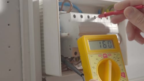 Work Under Voltage Electrician is Checking Serviceability of Equipment Measuring Voltage By Yellow