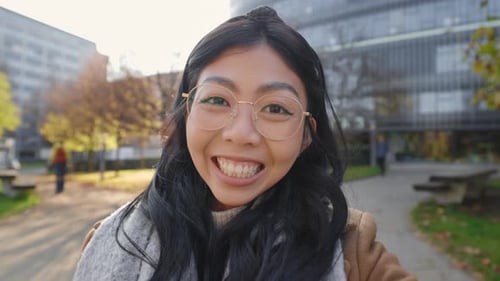 Smiling Young Woman Waving in an Urban Park