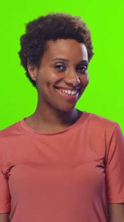 Portrait d'une jeune femme afro-américaine avec un sourire éclatant sur fond vert