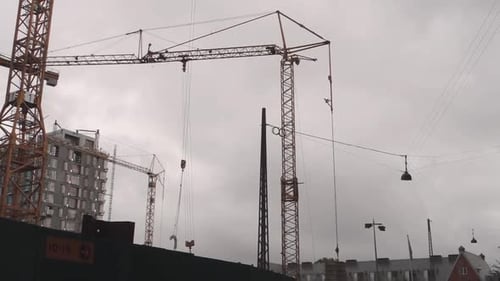 Towering Cranes Moving Building Materials in City