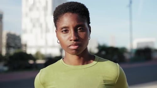 African Woman with Short Hair Looking at Camera Smiling in the Urban City Street