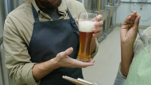 Diverse Brewmasters Inspecting Freshly Brewed Beer
