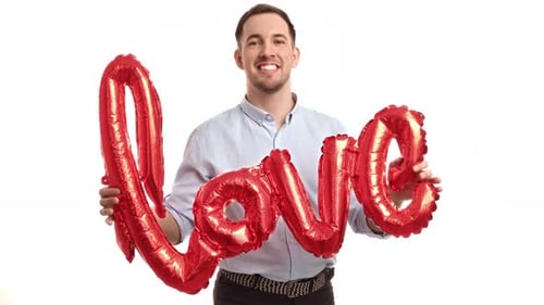 Young Man Holding Red Love Balloons Smiling