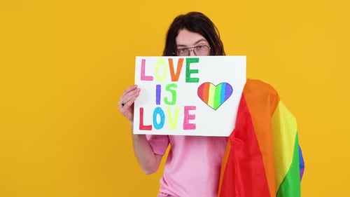 Attractive Gay Caucasian Bearded Man Holding a Protest Sign During a LGBT Pride Parade