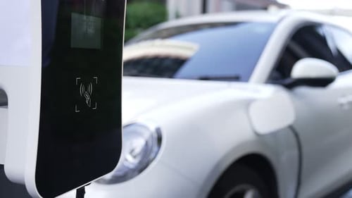 Progressive man pay for charging point to power rechargeable electric vehicle.