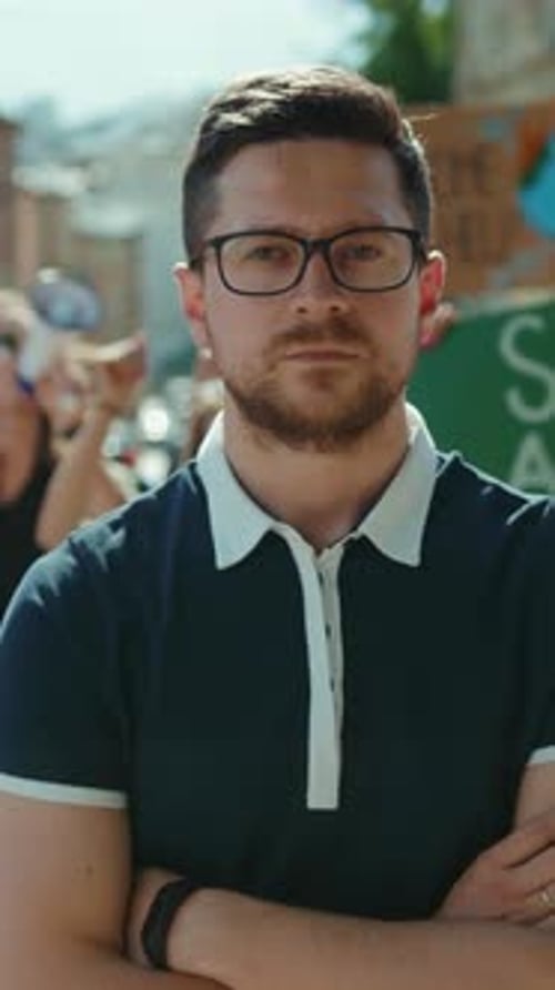 Stern Man With Arms Crossed at Outdoor Protest