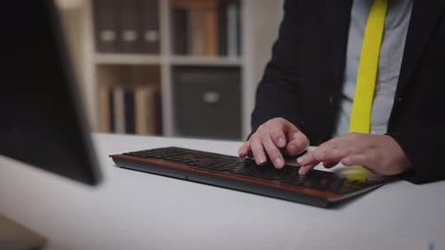 Man in Business Suit Typing on Computer Keyboard